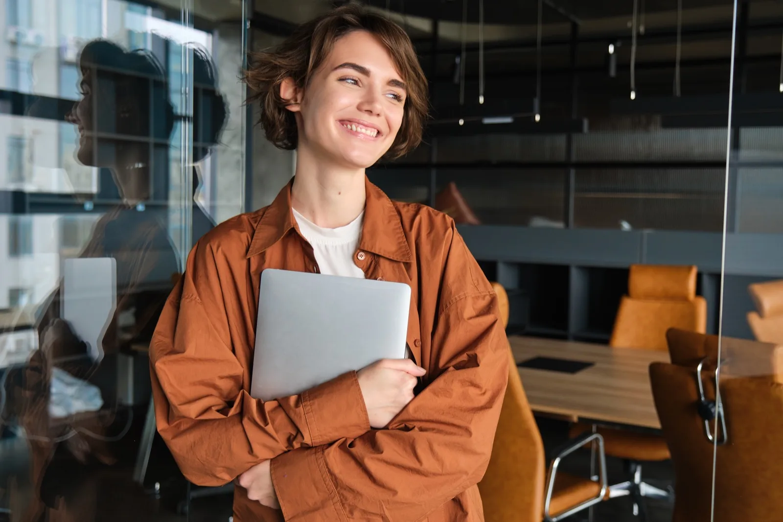 A professional woman smiling while working on her laptop